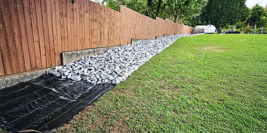 large rocks beside a fence